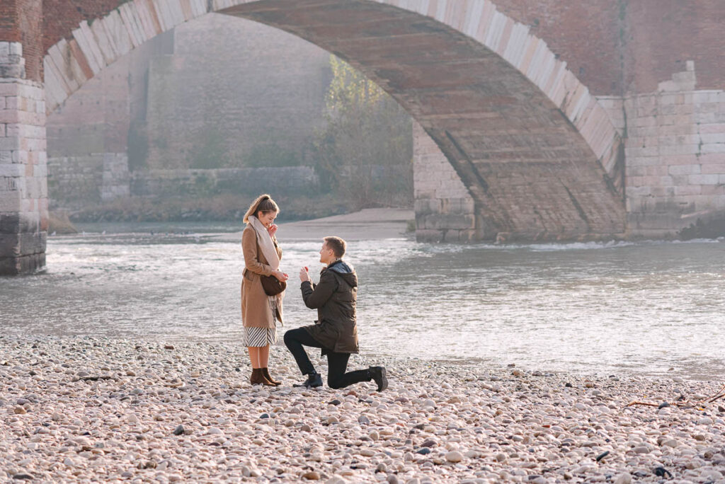 Man kneeling during marriage proposal at Castelvecchio bridge Verona