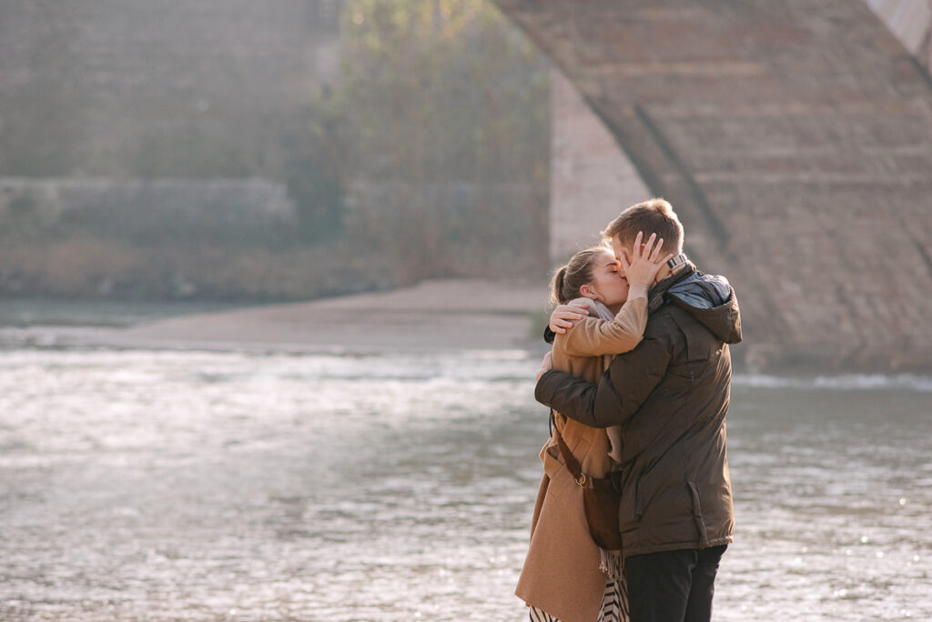 Couple embracing after proposal at Castelvecchio bridge Verona