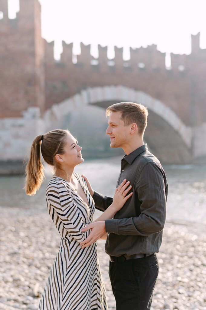 Natural portrait of couple by river after proposal in Verona