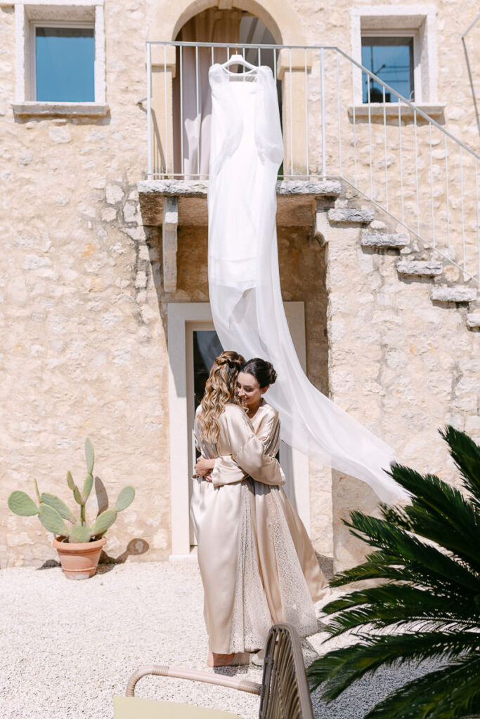 Sposa e damigella nel cortile durante la preparazione a Villa Mosconi Bertani