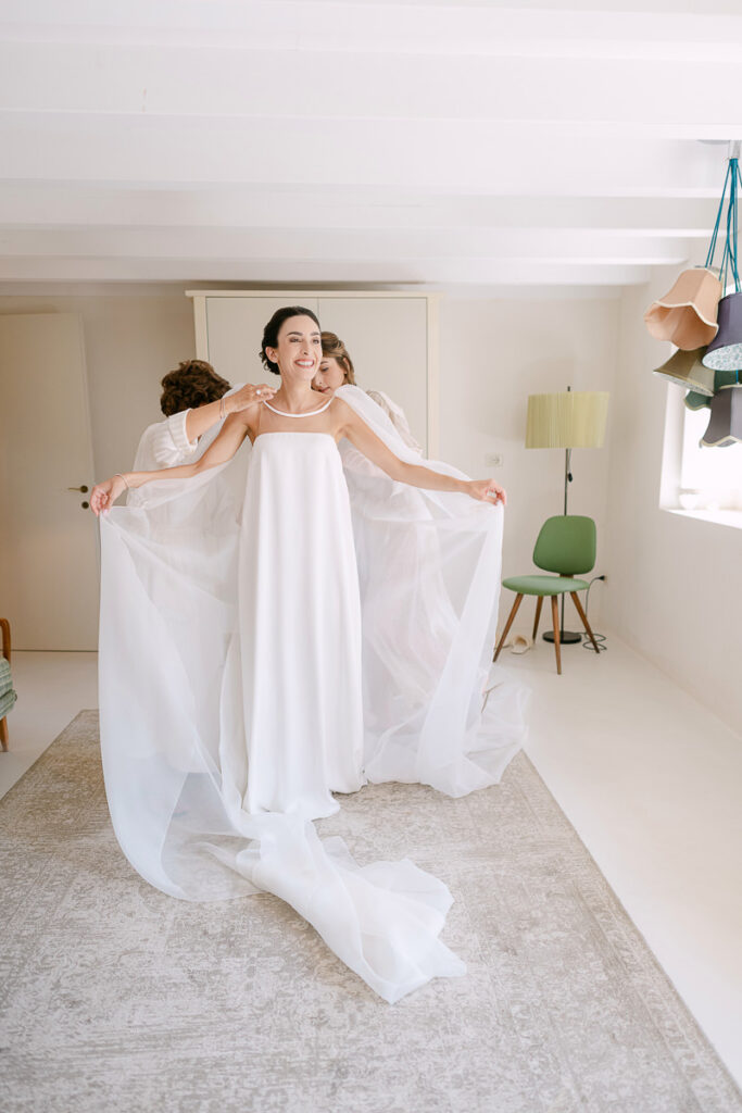 Sposa indossa l’abito durante la preparazione del matrimonio a Villa Mosconi Bertani