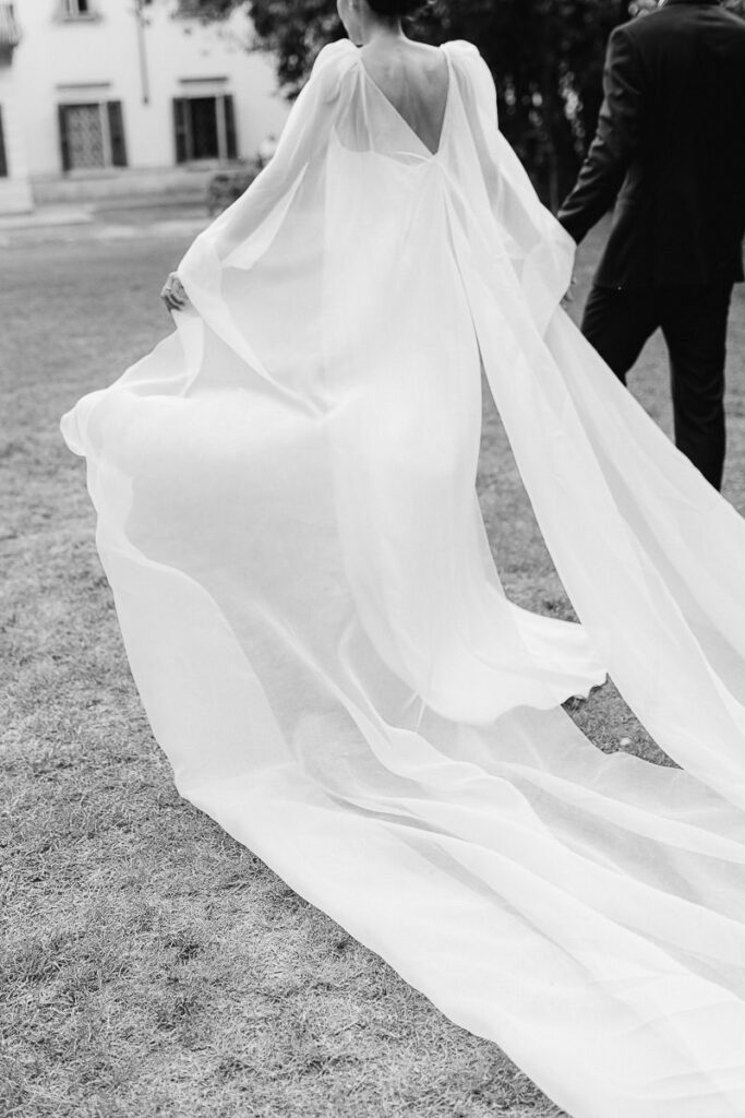 Sposi a Villa Mosconi Bertani durante un ritratto in bianco e nero con movimento dell’abito della sposa