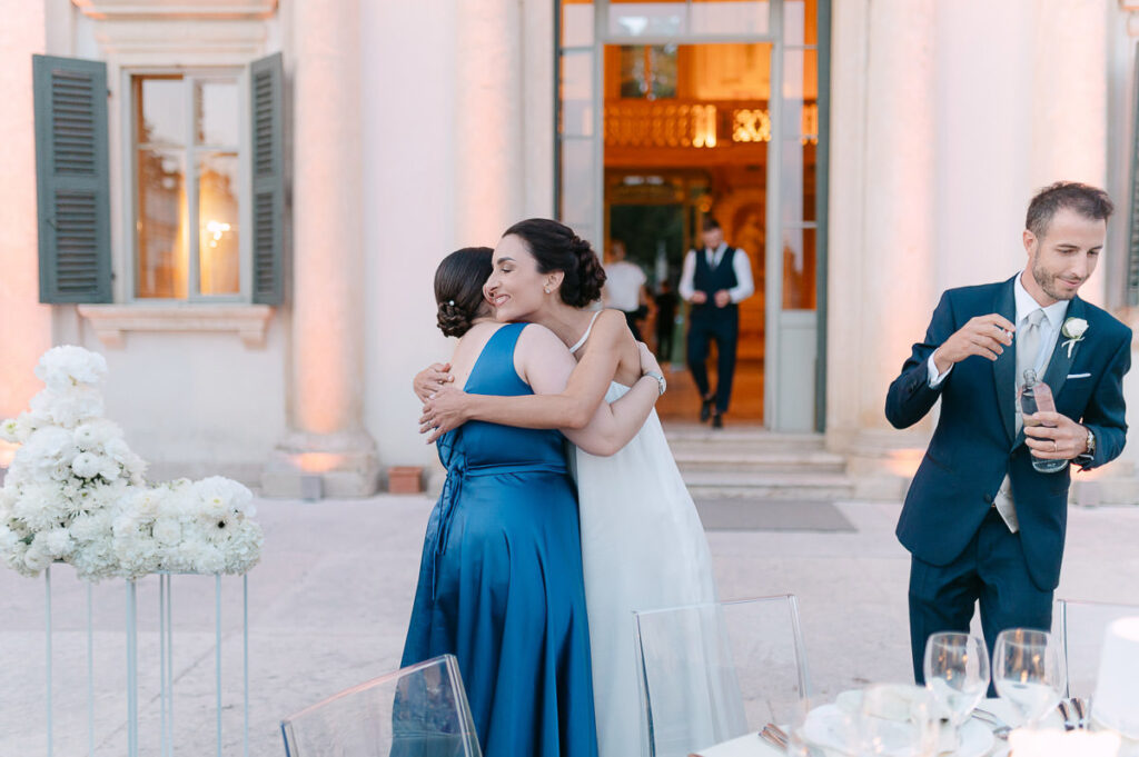 Abbraccio tra sposa e invitata durante il ricevimento di matrimonio a Villa Mosconi Bertani