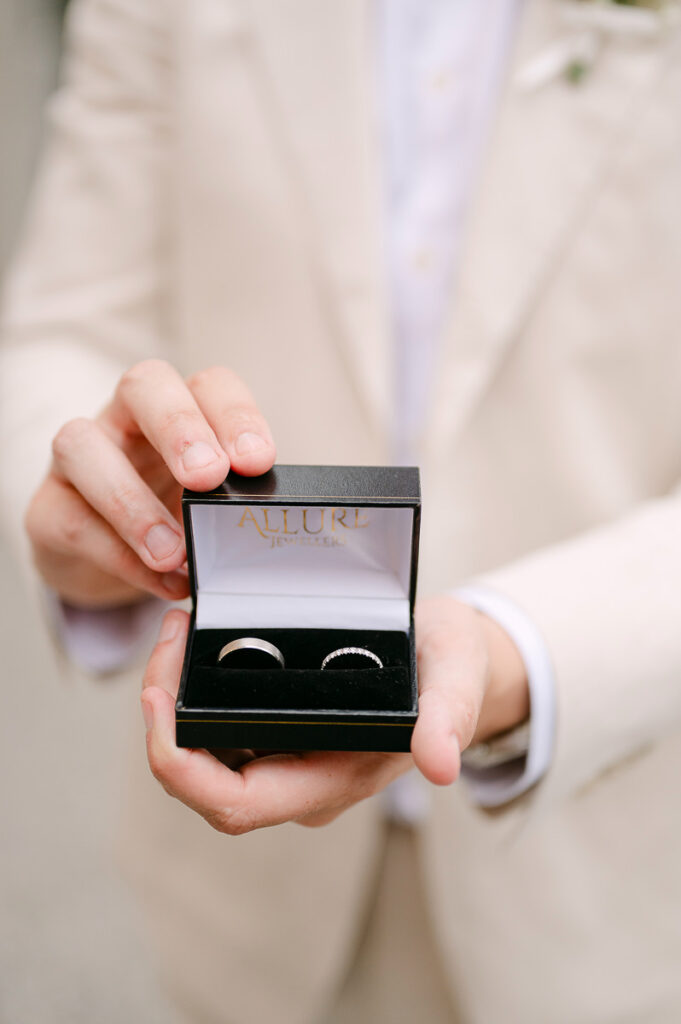 Groom holding wedding rings close-up