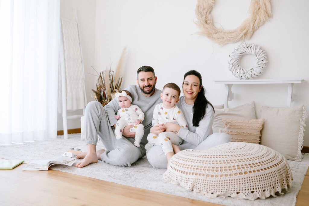 Famiglia con due bambini seduta in casa durante un servizio fotografico di famiglia a Verona in ambiente domestico
