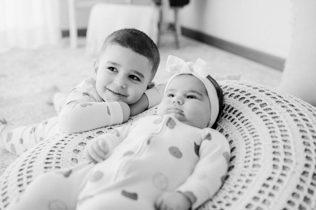 Due bambini sdraiati insieme durante un servizio fotografico di famiglia in ambiente domestico a Verona