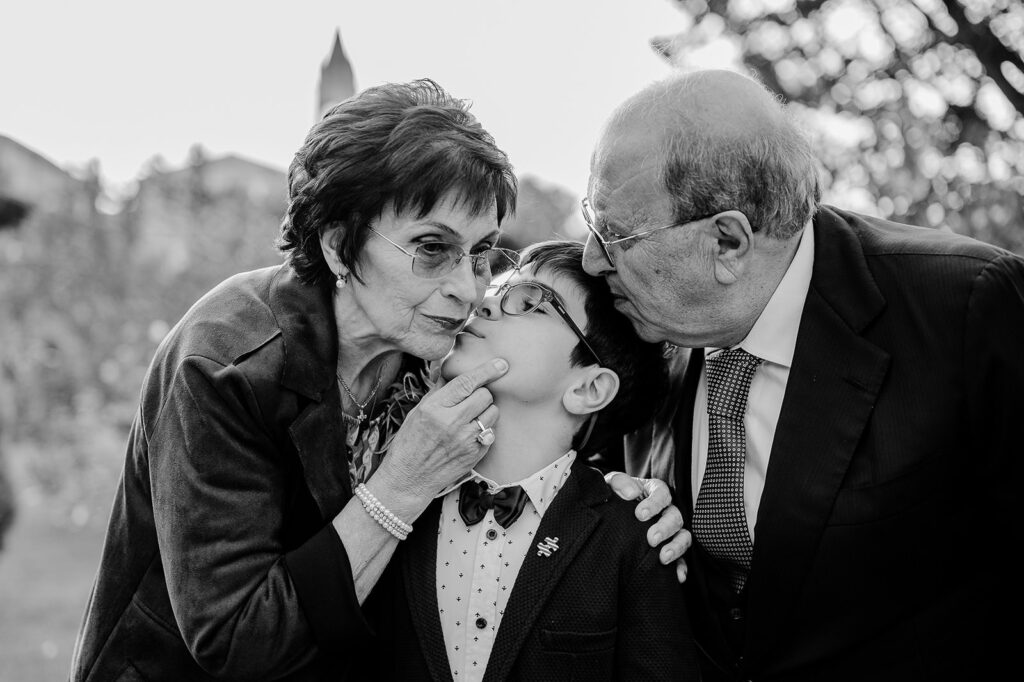 Nonni che baciano il nipote durante un momento spontaneo in bianco e nero in un servizio fotografico di famiglia